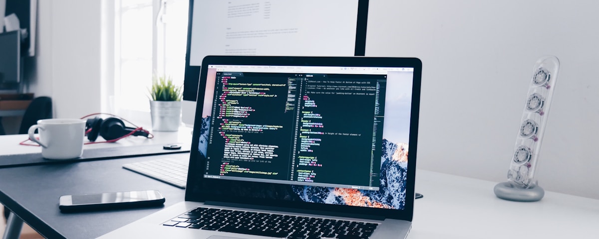 Developer working on a modern website with laptop and code editor
